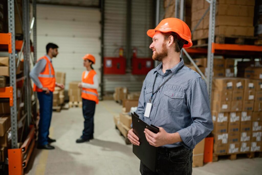 Mitarbeiter mit Schutzhelm und Klemmbrett in einem Lager für Haustierbedarf – Symbolbild für „Wir kaufen Haustierbedarf, den du nicht mehr verkaufen kannst“ von Get Rid Of It
