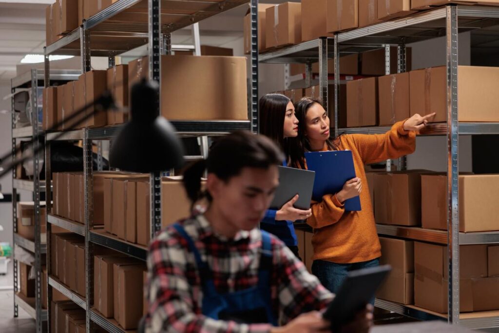 Mitarbeiter im Lager prüfen Kartons und Produktbestände – Symbolbild für „Wir kaufen Spielzeug und Kinder- und Babyprodukte“ von Get Rid Of It